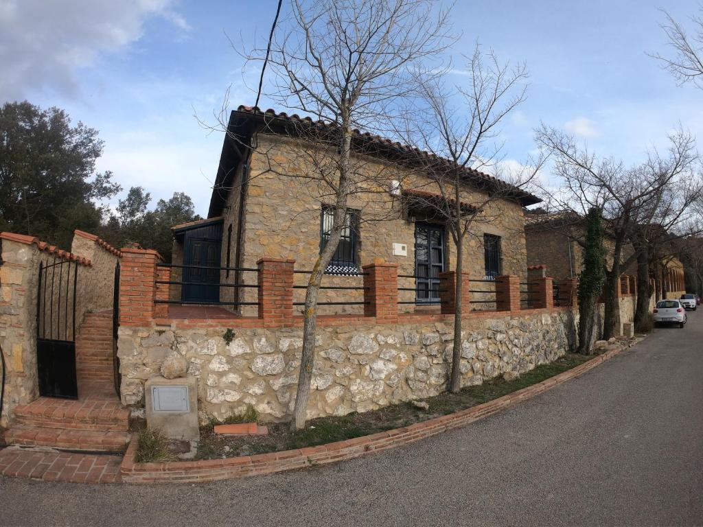 een stenen huis met een stenen muur naast een straat bij xalet l’avella 2 in Catí