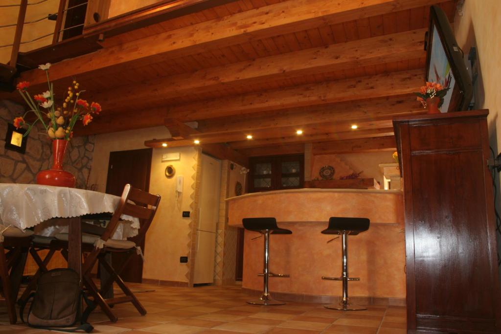 a kitchen with a table and stools in a room at Alla Corte dei Ventimiglia in Montelepre