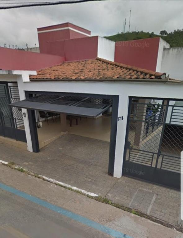 a building with a large garage with a roof at Suítes Dona Paris in Capitólio