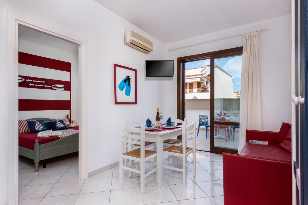 a living room with a bed and a table in a room at Le Palme Di Conturrana in San Vito lo Capo