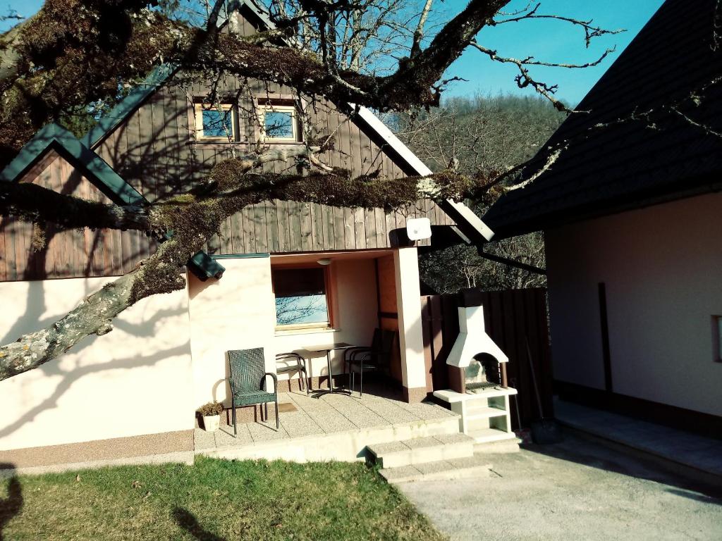 ein Haus mit einem Tisch und Stühlen im Hof in der Unterkunft apartma HIŠKA KOROŠEC in Bohinj