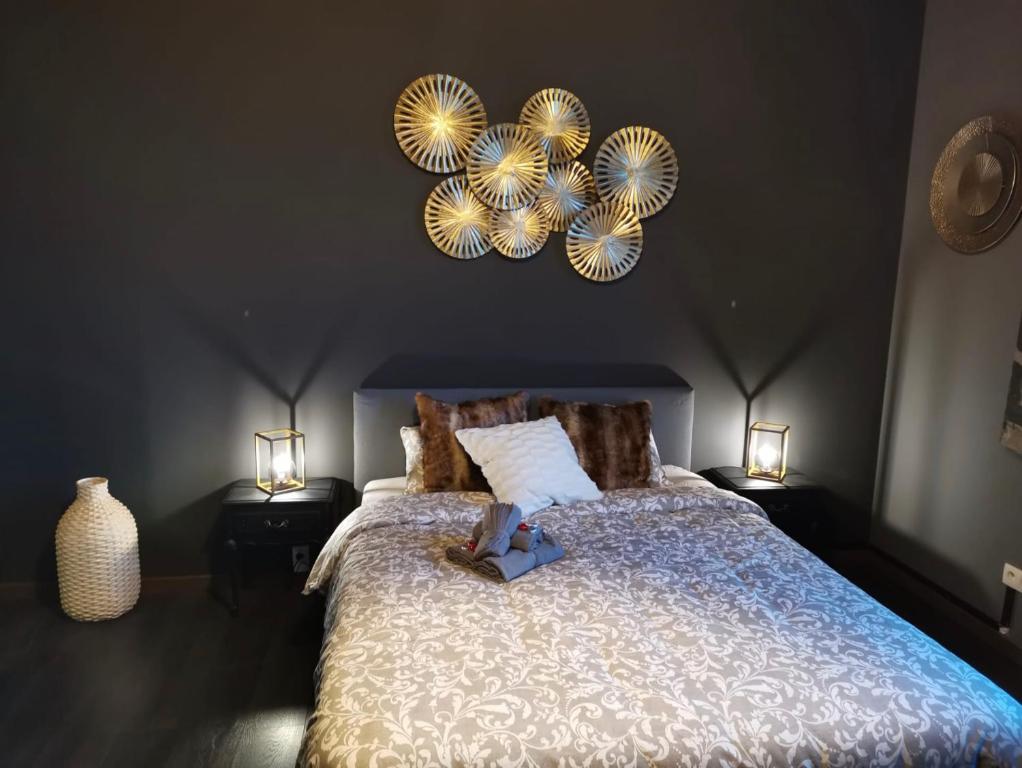 a bedroom with a bed with two lights on the wall at LA SUITE 159 in Namur