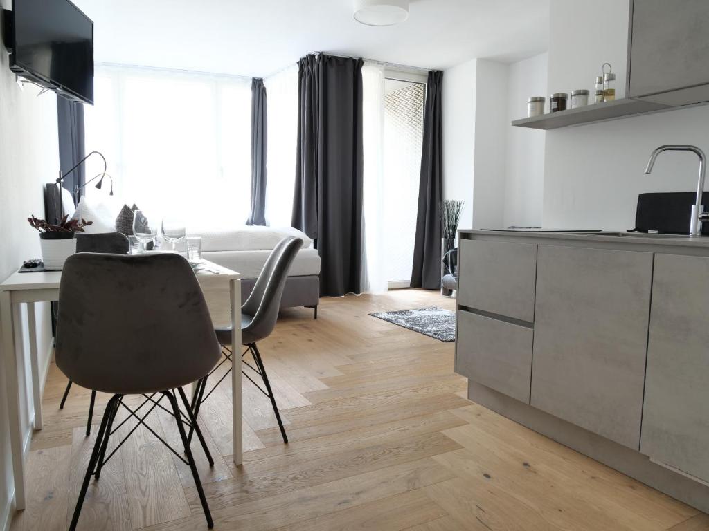 een keuken met een bureau en een tafel met een stoel bij Apartments Sabine K in Merano
