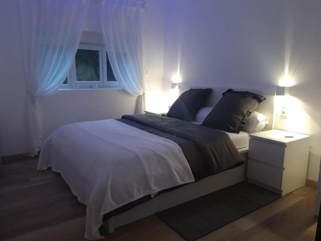 Schlafzimmer mit einem Bett mit blauen Vorhängen und einem Fenster in der Unterkunft Gite du nuage in Fontenay-Torcy