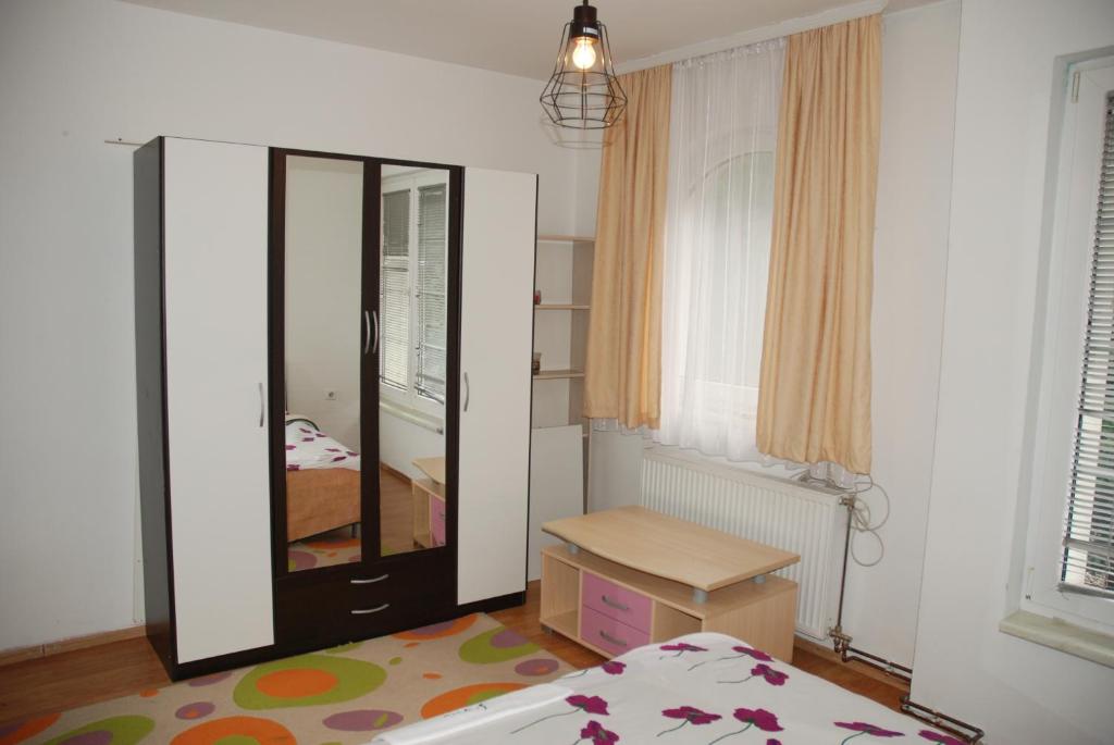 een slaapkamer met een spiegel, een bed en een dressoir bij Vila Ratković in Banja Luka