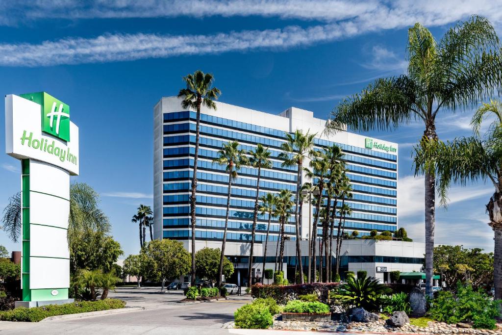 Holiday Inn Los Angeles Gateway-Torrance, an IHG Hotel في تورانس: مبنى مكتب أمامه أشجار نخيل