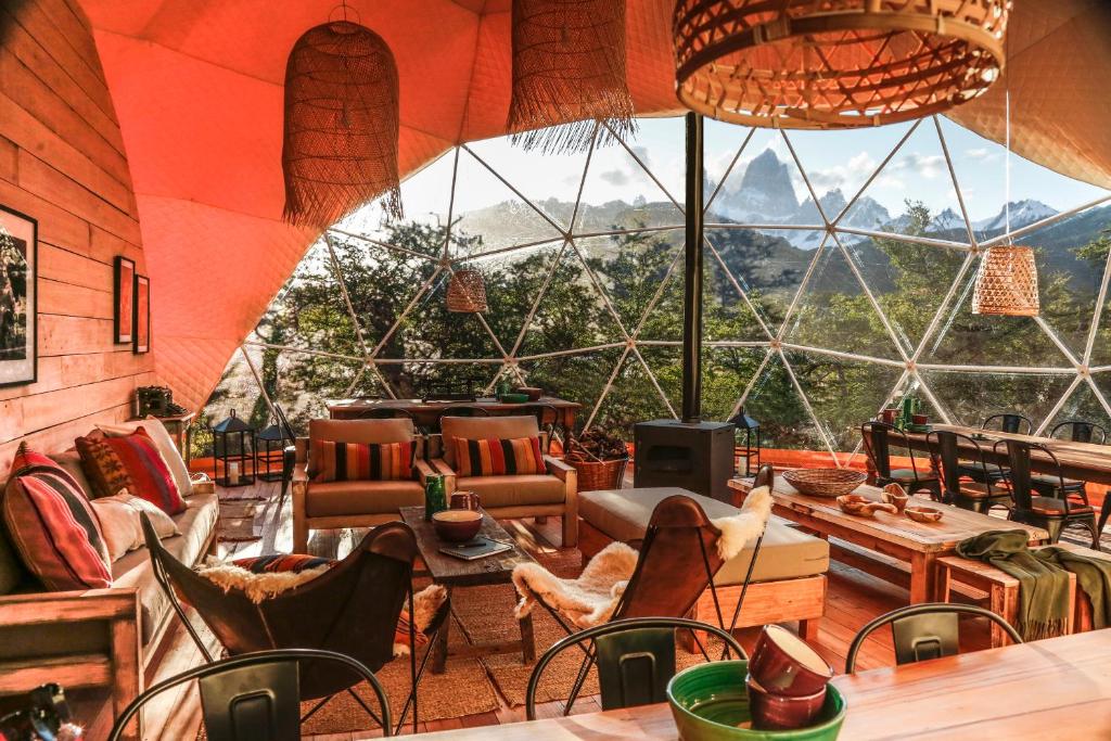 a room with a large window with chairs and tables at Chalten Camp - Glamping with a view in El Chalten