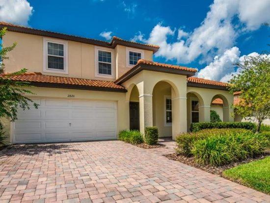 a house with a brick driveway in front of it at Tuscany at Westside Luxury 5 Bed, 4 Bath Villa near Disney in Kissimmee