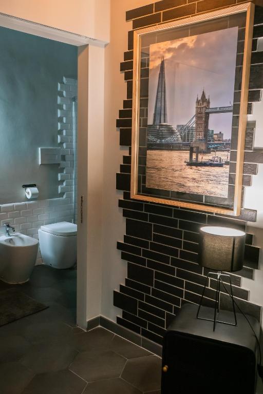 a bathroom with a large picture on the wall at Vinto House Salerno Downtown in Salerno