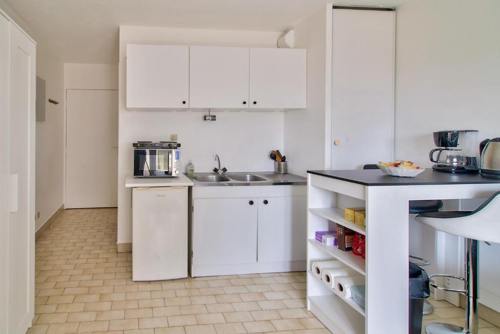 a kitchen with white cabinets and a sink at STUDIO DESIGN NEAR GENEVA in Étrembières
