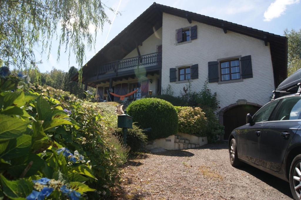 uma casa com um carro estacionado em frente em Lullaby House - Large, full comfort 5 star chalet house in the Vosges em Ramonchamp