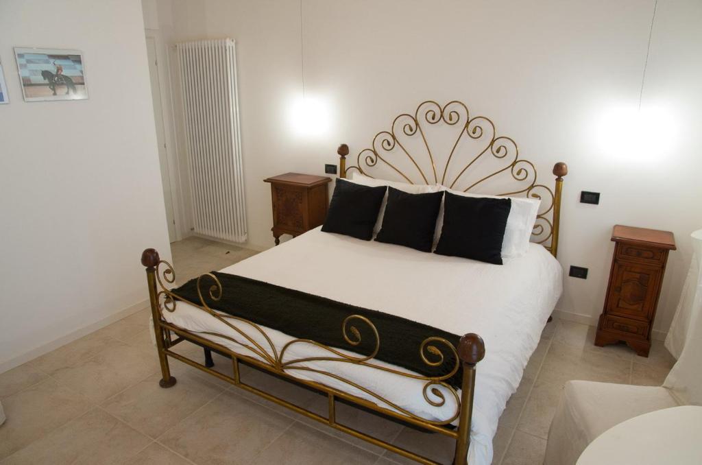 a bedroom with a large bed with black pillows at B&B Marostica in Marostica