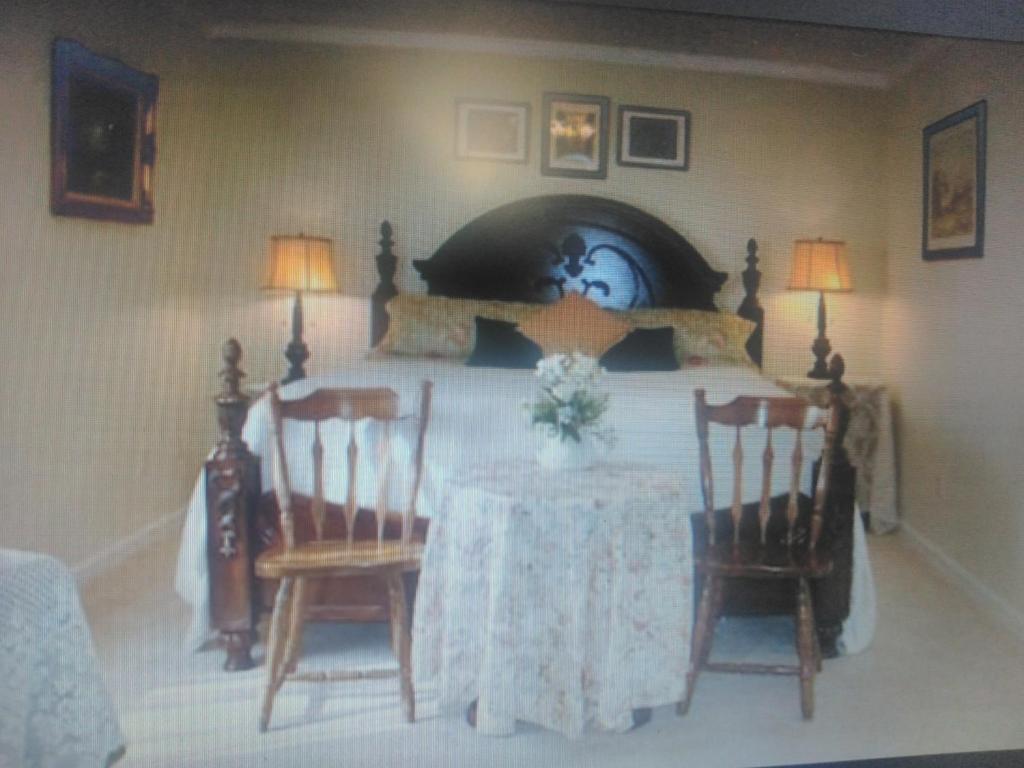 a bedroom with a bed with a table and two chairs at Serenity Hill b&b in Sloans Crossing