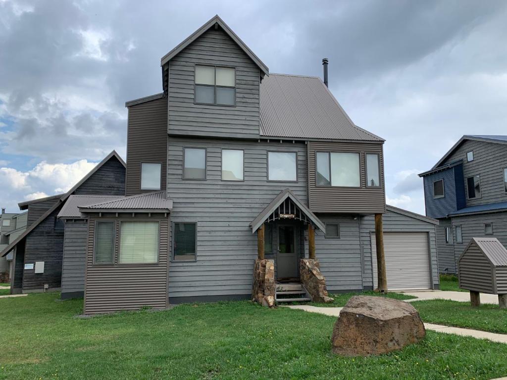 a gray house with a gambrel roof at Dragonfly Chalet in Dinner Plain