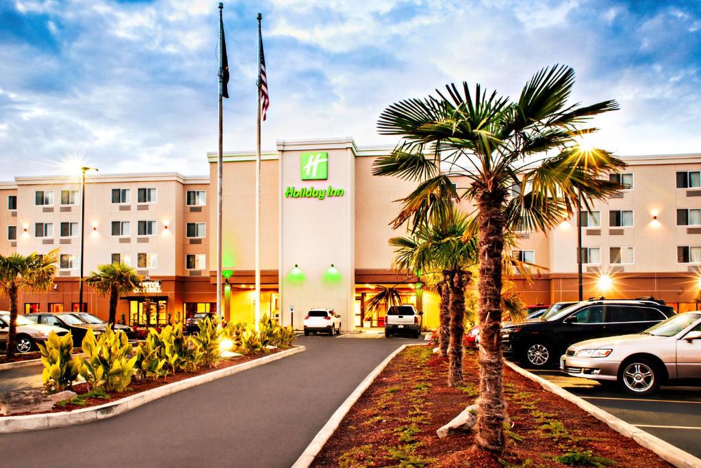a hotel with a palm tree in front of a building at Holiday Inn - Salem, an IHG Hotel in Salem