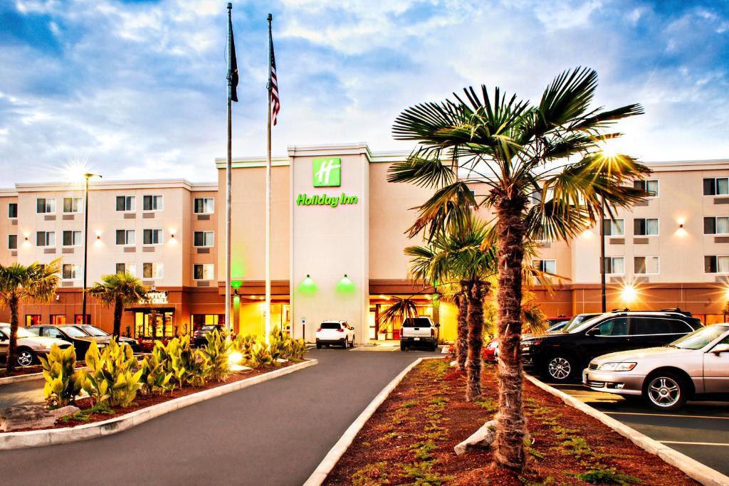 un hotel con una palmera frente a un edificio en Holiday Inn - Salem, an IHG Hotel, en Salem