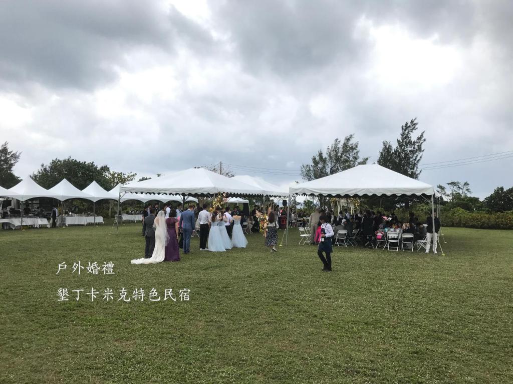 a group of people standing under white tents at Kenting COMIC B&amp;B in Hengchun South Gate