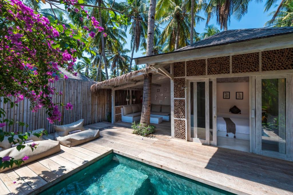 un patio trasero con piscina y una casa en Villas Edenia, en Gili Trawangan