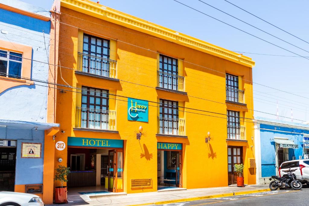 a yellow building with a hotel on a street at Happy Express Hotel in Oaxaca City