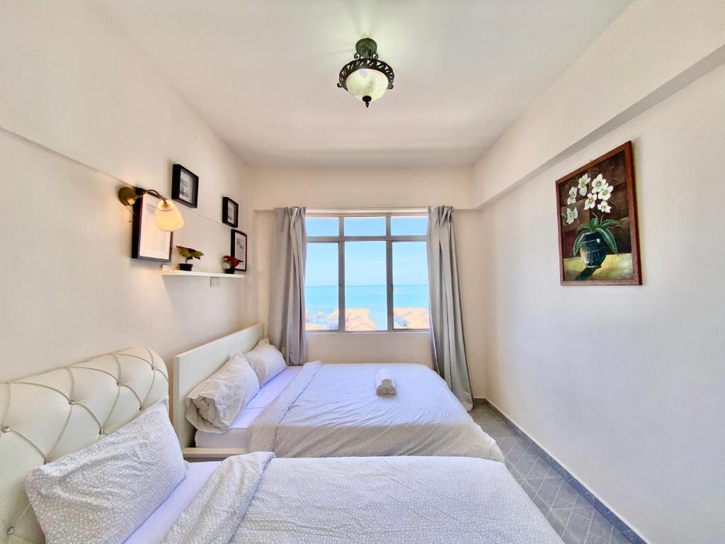 a bedroom with a bed and a window at Maison Seaview Suites Port Dickson in Port Dickson