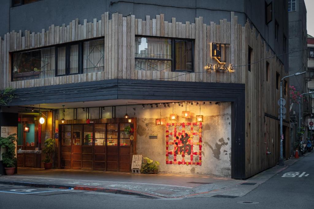 una tienda frente a un edificio en una calle de la ciudad en Cho Hotel en Taipéi