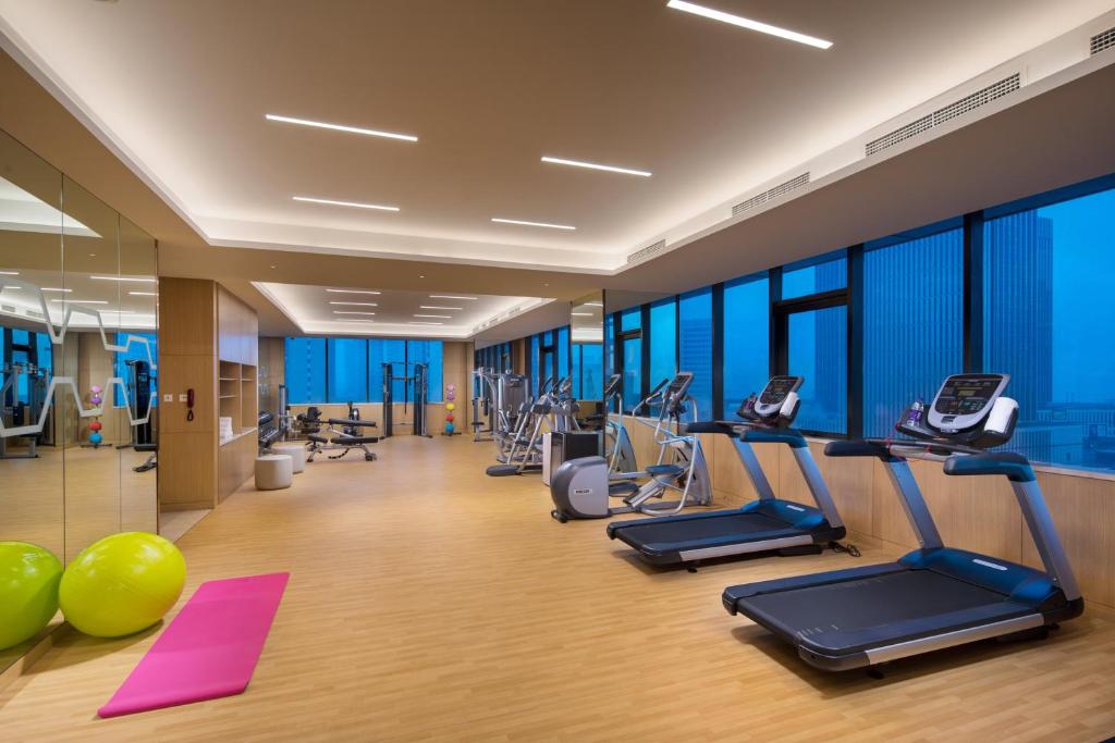 a gym with treadmills and exercise equipment in a building at Holiday Inn Tianjin Xiqing, an IHG Hotel in Tianjin