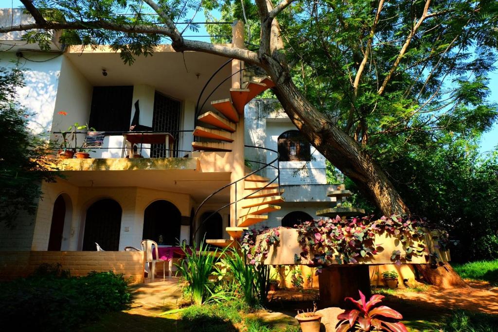 a house with a staircase in front of it at New Creation Guest House in Auroville