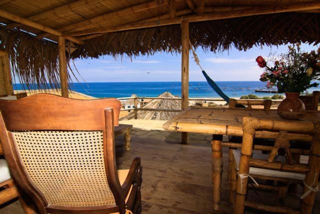 einen Tisch und Stühle mit einem Tisch und Meerblick in der Unterkunft Oceanic Bungalows in Los Órganos