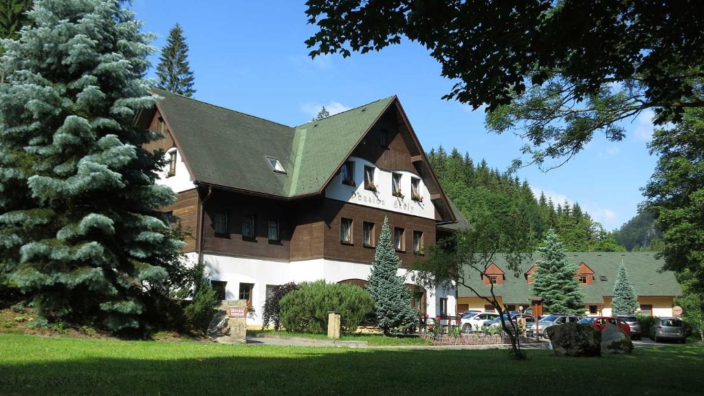 uma casa grande com um telhado verde em Pension Skály em Teplice nad Metují