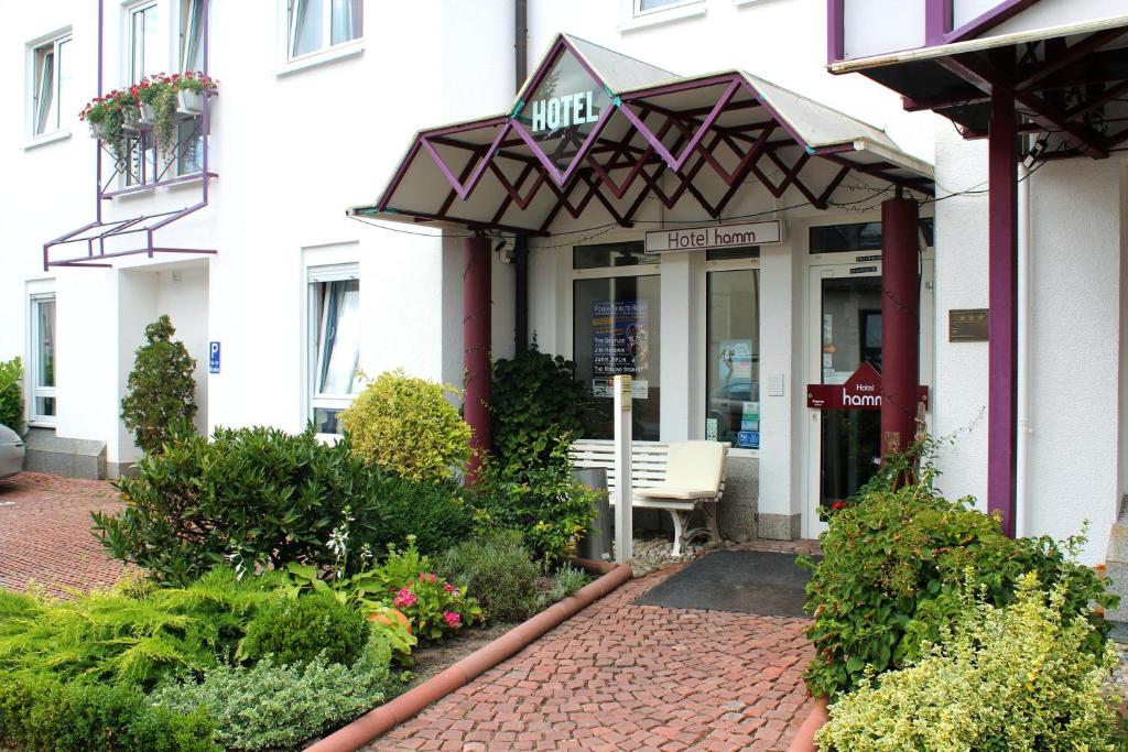 een ingang naar een gebouw met een bank voor de deur bij Hotel Hamm in Weiterstadt