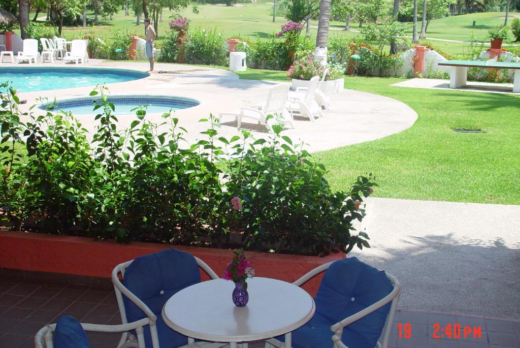 a white table and chairs next to a pool at Coral Ixtapa in Ixtapa