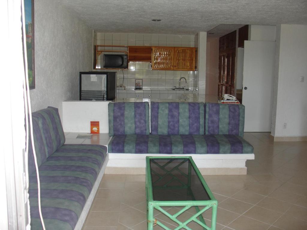 a living room with a couch and a kitchen at Coral Ixtapa in Ixtapa