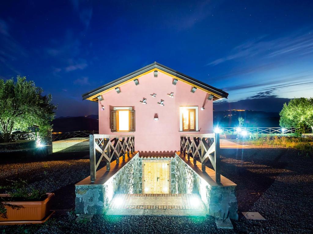 a pink house with lights on it at night at Fontana del Cherubino in Santa Maria di Licodia