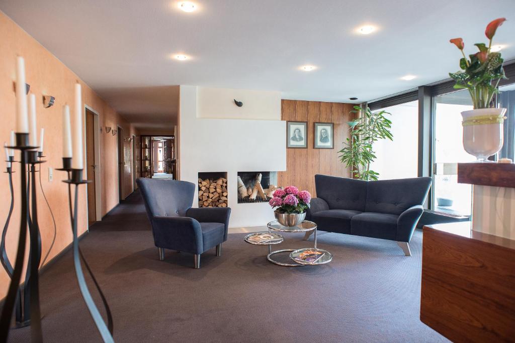 een woonkamer met twee stoelen en een open haard bij Hotel Kögel in Erbach