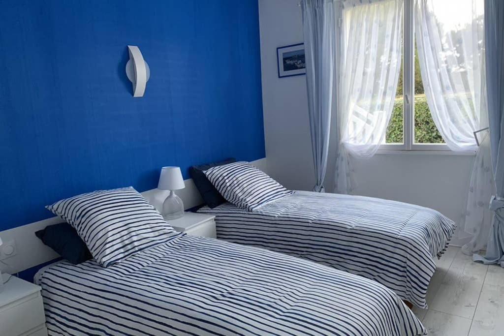 2 Betten in einem Zimmer mit blauen Wänden in der Unterkunft Ar Marc'h-Mor Glaz 3 étoiles in Cléder