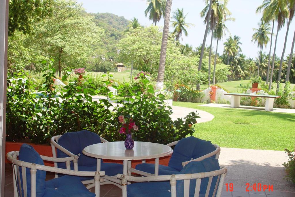 a table with two chairs and a table with a vase at Coral Ixtapa in Ixtapa