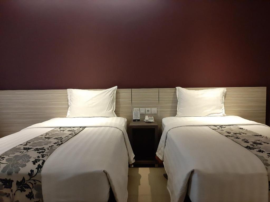 A bed or beds in a room at Hotel Asri Sumedang