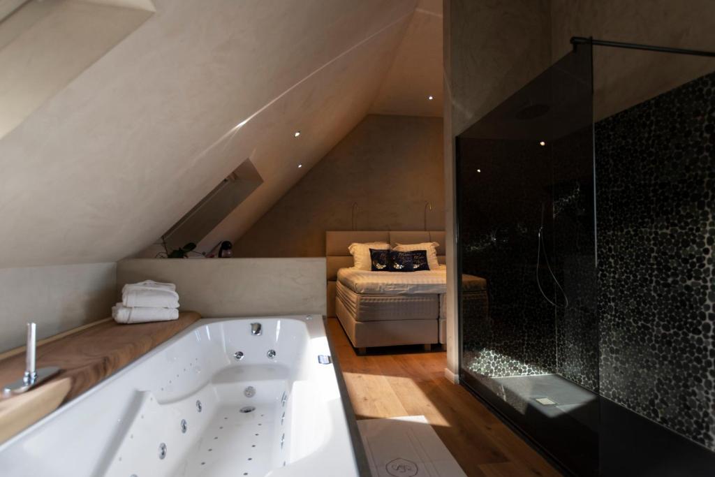 uma casa de banho com banheira num sótão em Wellness Sweet Bonihu B&B em Bruges