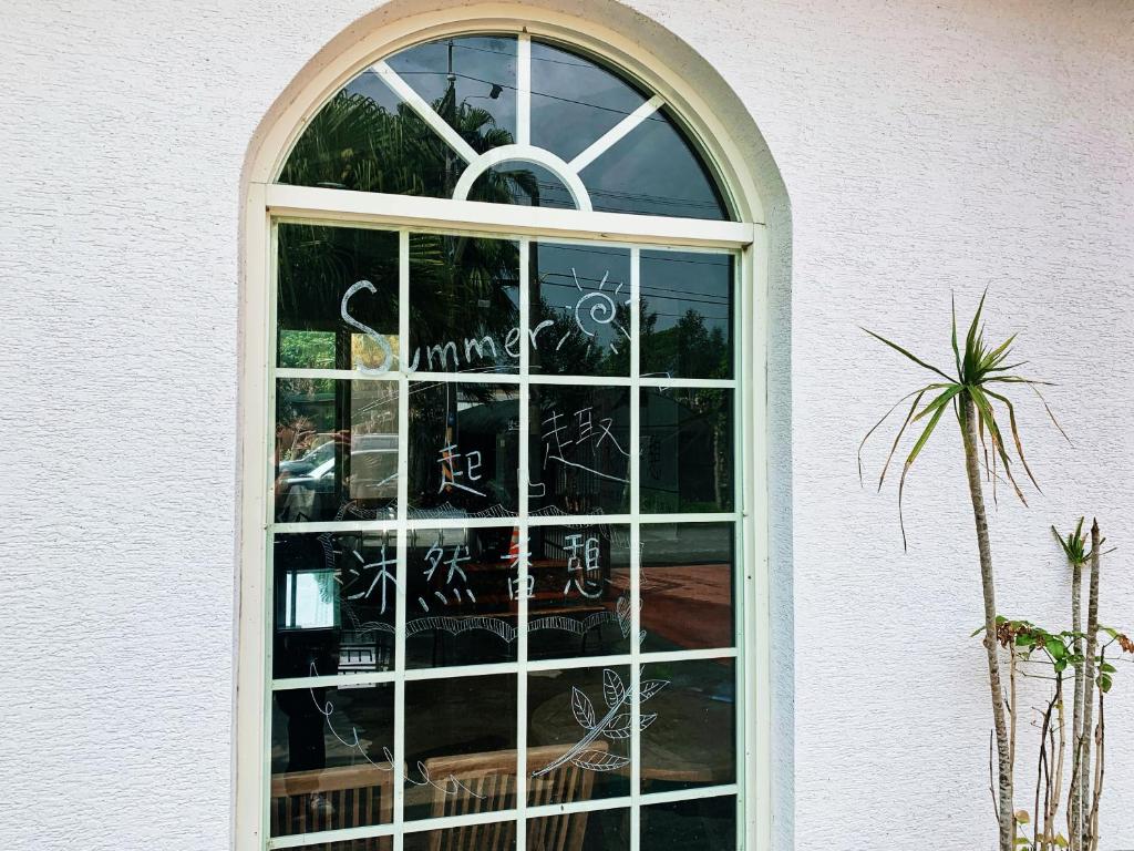 ein großes Fenster in einem weißen Gebäude mit Schreiben darauf in der Unterkunft Natural Essence of Hot Spring in Jiaoxi