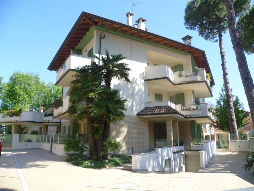 a building with a palm tree in front of it at Residence La Rotonda in Cervia