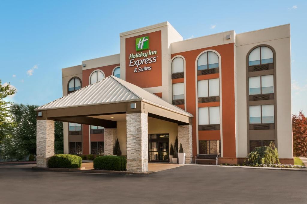 un edificio de oficinas con un cartel en la parte delantera en Holiday Inn Express Hotel & Suites Bentonville, an IHG Hotel, en Bentonville