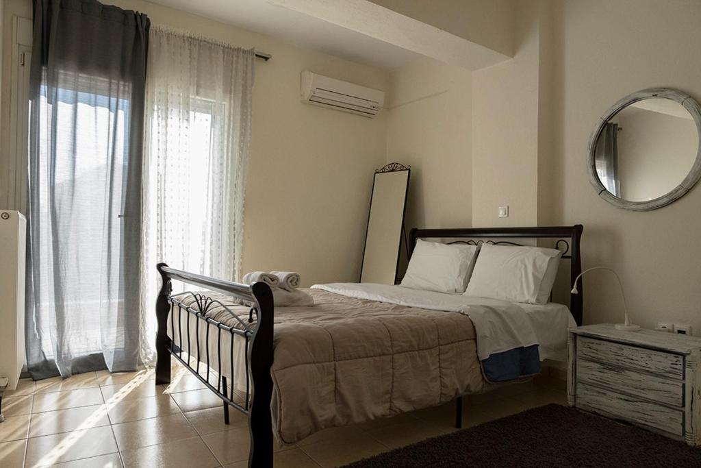 テッサロニキにあるZefiron Flatのベッドルーム1室(ベッド1台、鏡、窓付)