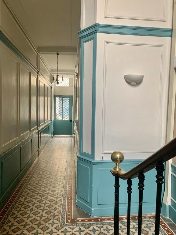 a hallway with a blue wall and a staircase at Appartement Versailles quartier Notre Dame au pied du Chateau avec Parking in Versailles