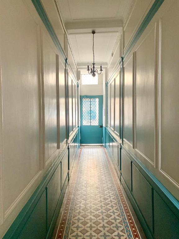 an empty corridor in a building with a green wall at Appartement Versailles quartier Notre Dame au pied du Chateau avec Parking in Versailles
