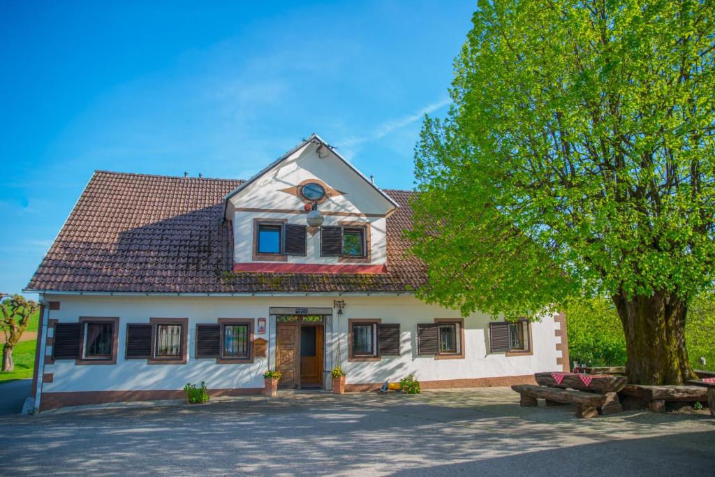 Una casa blanca con un árbol delante. en Holiday Farm Grofija en Ivančna Gorica