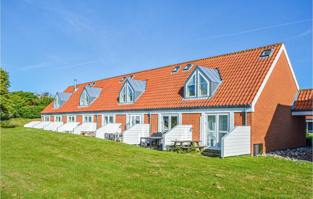 ein Haus mit weißen Stühlen und einem orangenen Dach in der Unterkunft Lovely Apartment In Lemvig With Kitchen in Lemvig