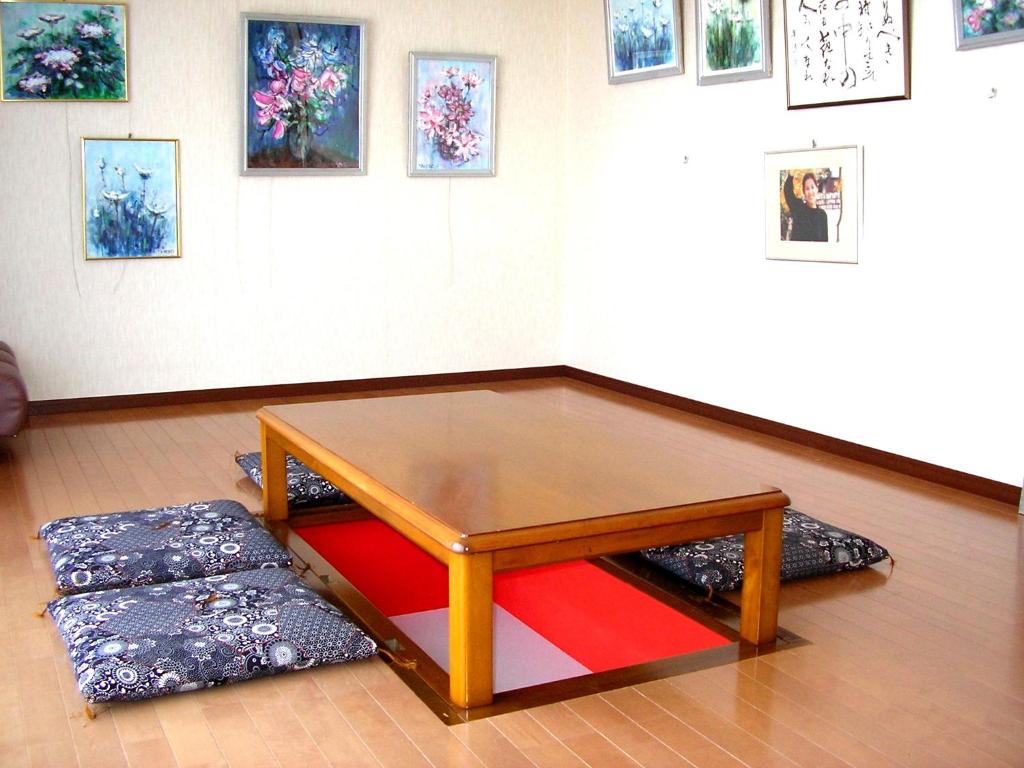 a coffee table in a room with paintings on the wall at 民泊コスモス in Yatsuo