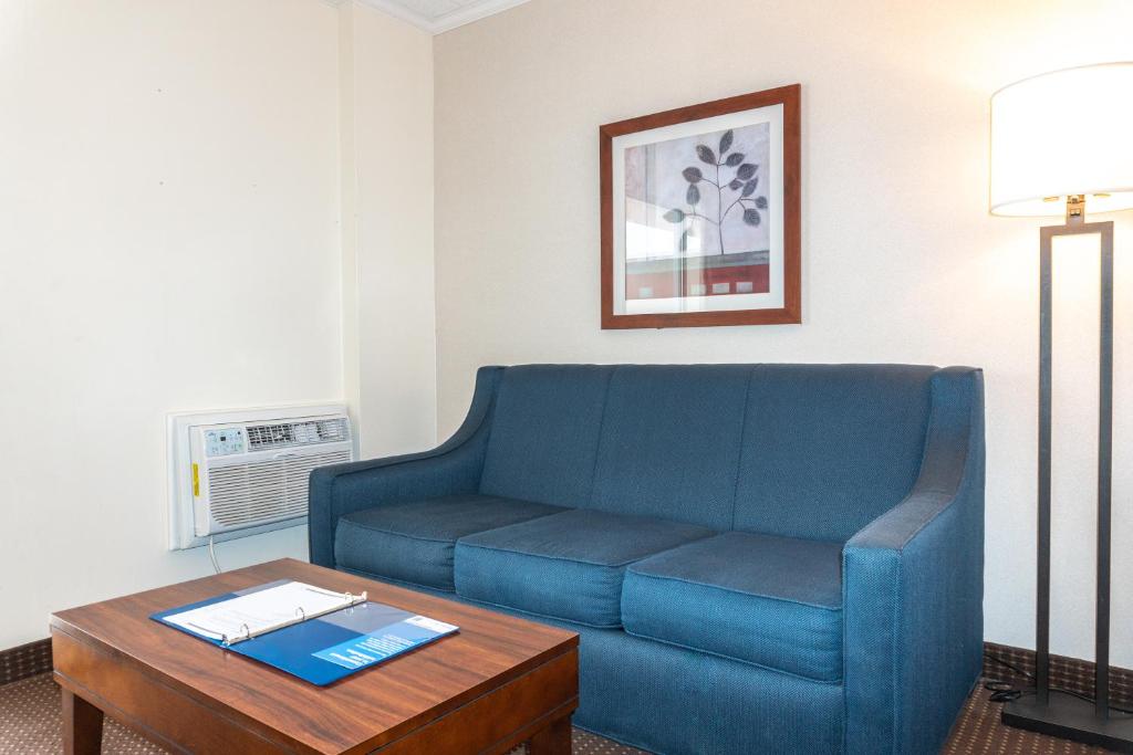 a living room with a blue couch and a table at Comfort Inn Ocean City Boardwalk in Ocean City