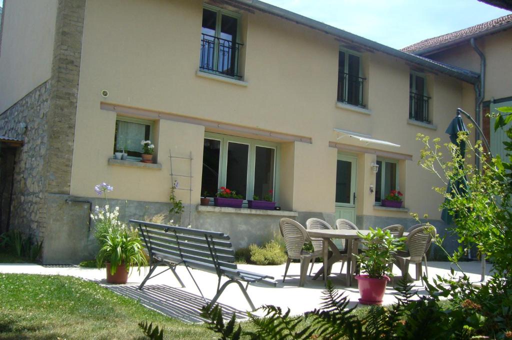 een patio met een tafel en stoelen voor een huis bij Gîte Bulle de Miel in Berru