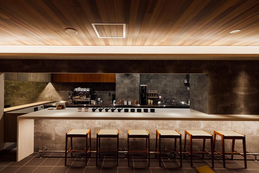 a bar with stools in front of a kitchen at KéFU stay & lounge in Kyoto